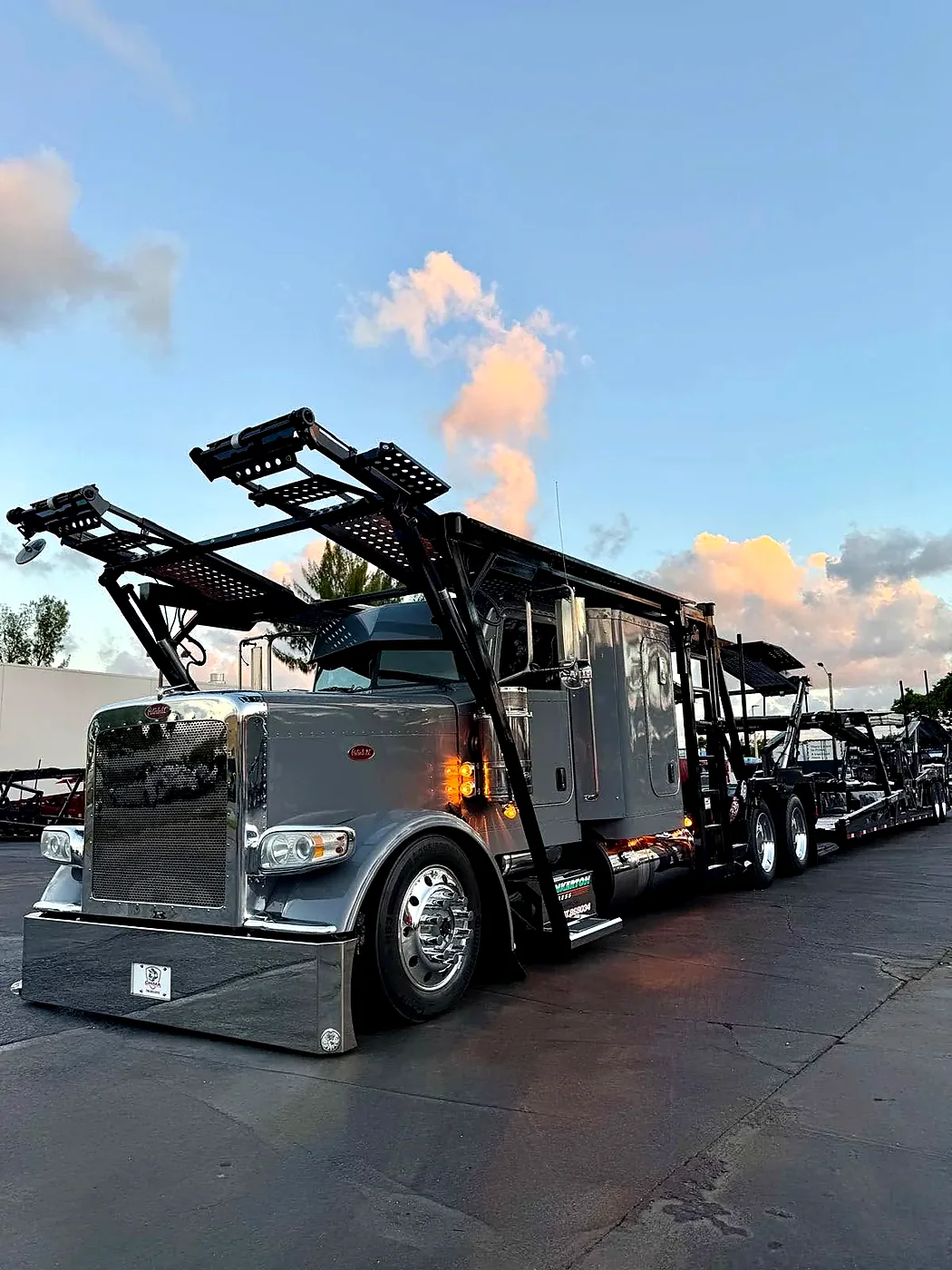 Automobile transporter tractor and multi-level trailer parked outdoors.