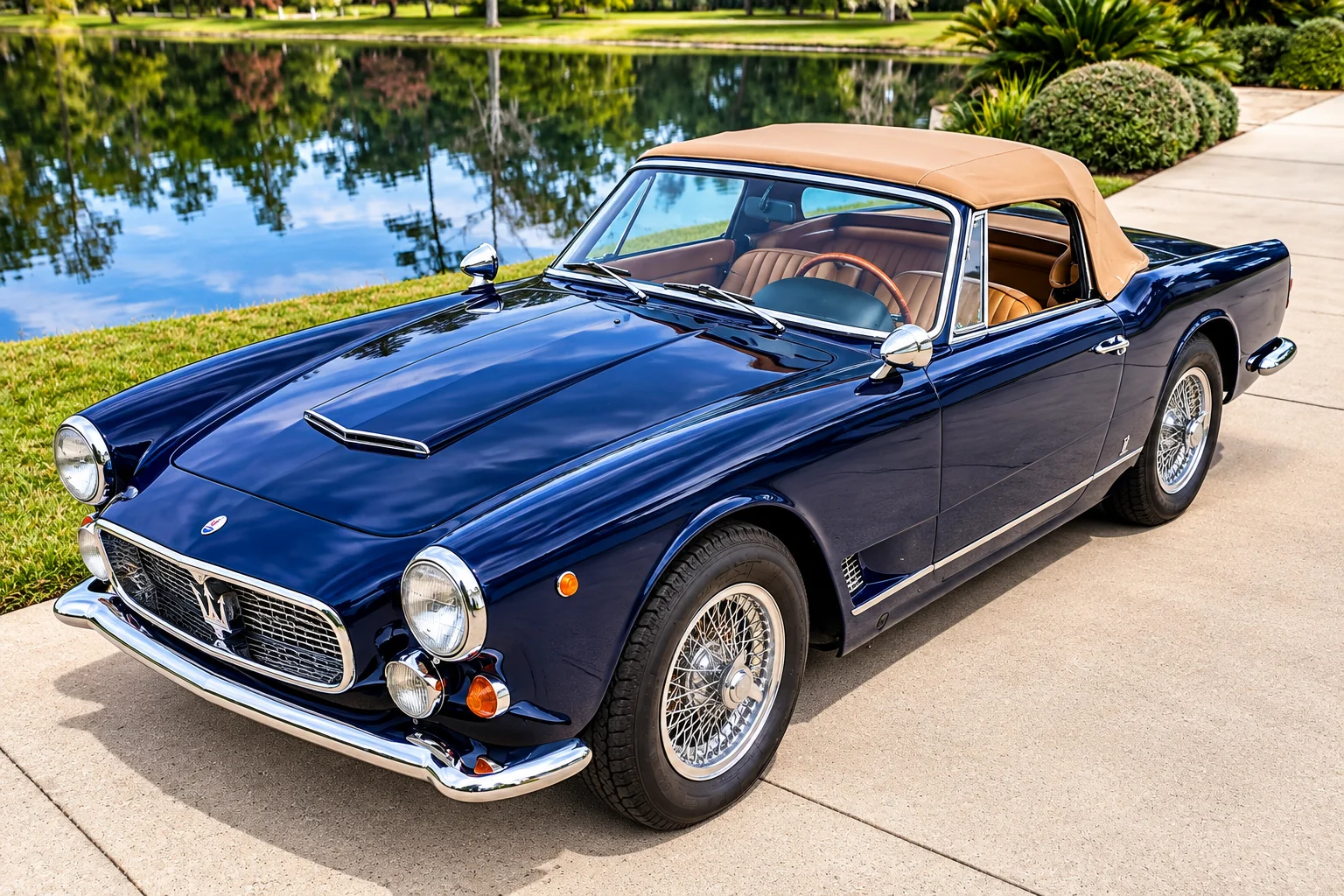 Dark blue classic convertible parked near a lake.